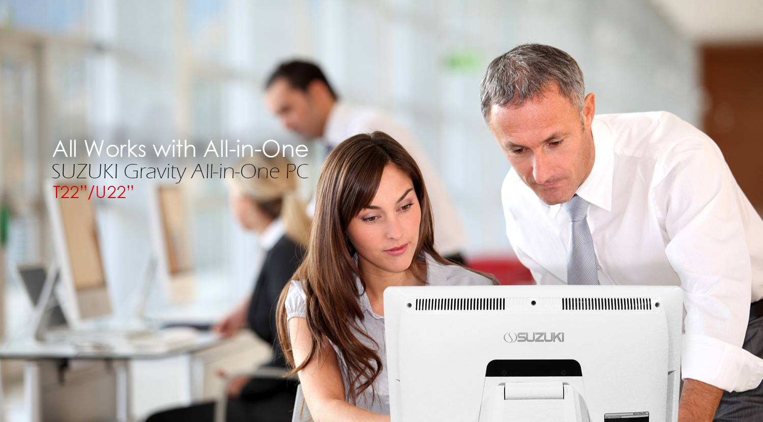 Business colleagues looking at a white Suzuki Gravity All-in-One PC monitor in an office.