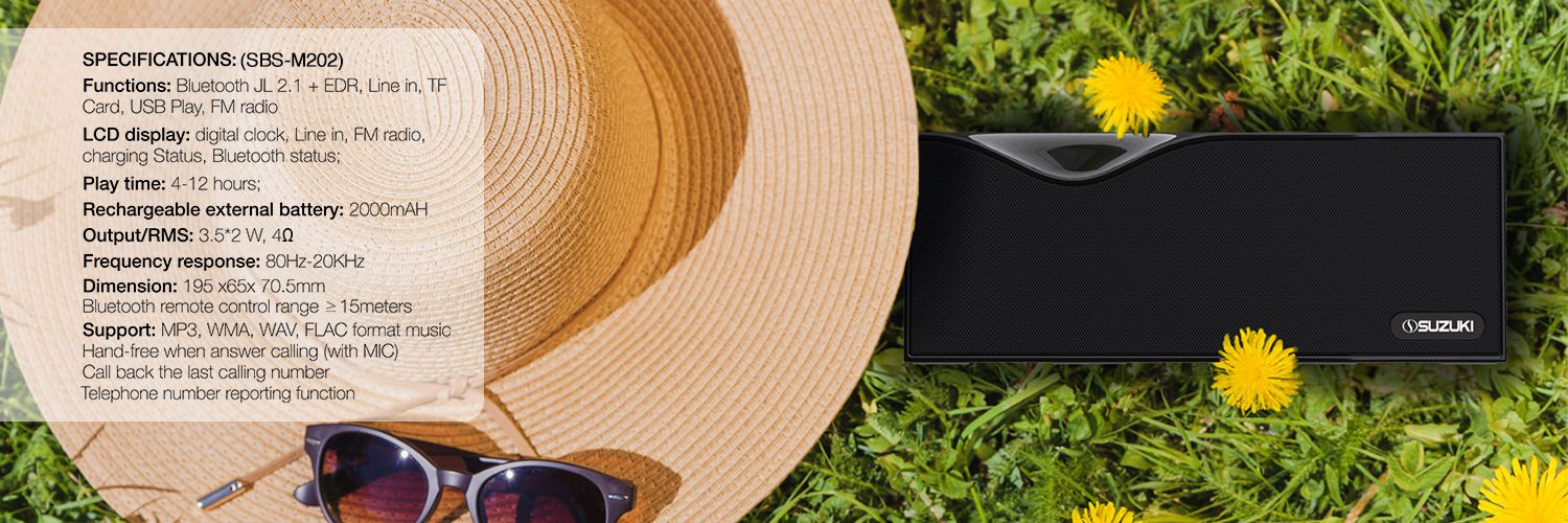 Black Suzuki SBS-M202 speaker on grass near a straw hat and sunglasses, accompanied by a list of technical specifications.