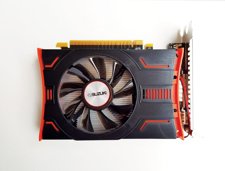 Black and orange Suzuki graphics card with a single cooling fan and gold connector pins against a white background.