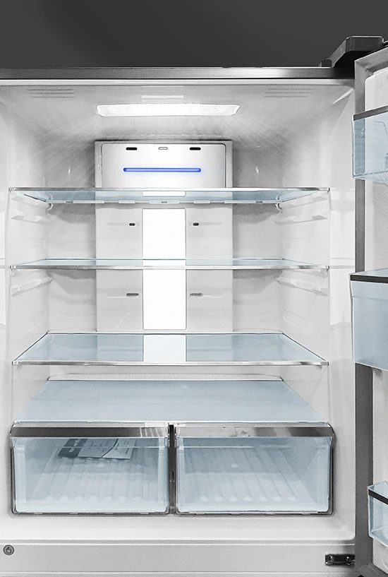 Open view of a clean, empty refrigerator interior featuring glass shelves, dual crisper drawers, and a top cooling unit with