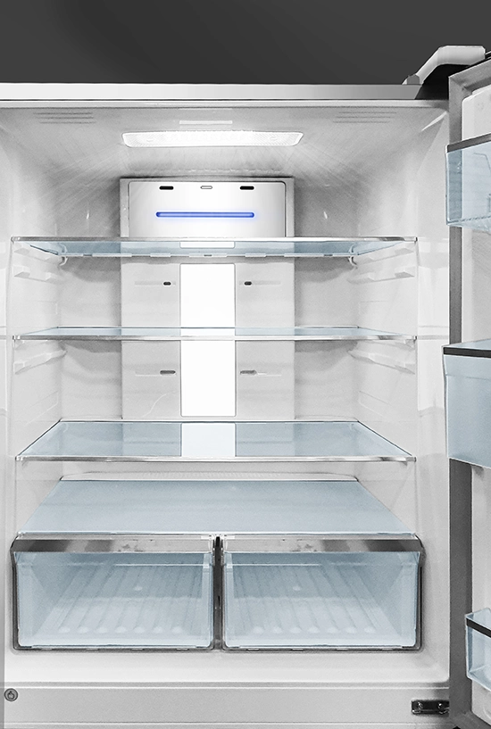 Interior view of a clean, empty refrigerator featuring glass shelves, dual crisper drawers, and a back panel with blue lighti