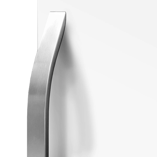 Close-up of a sleek, curved brushed metal handle mounted vertically on a clean white cabinet surface