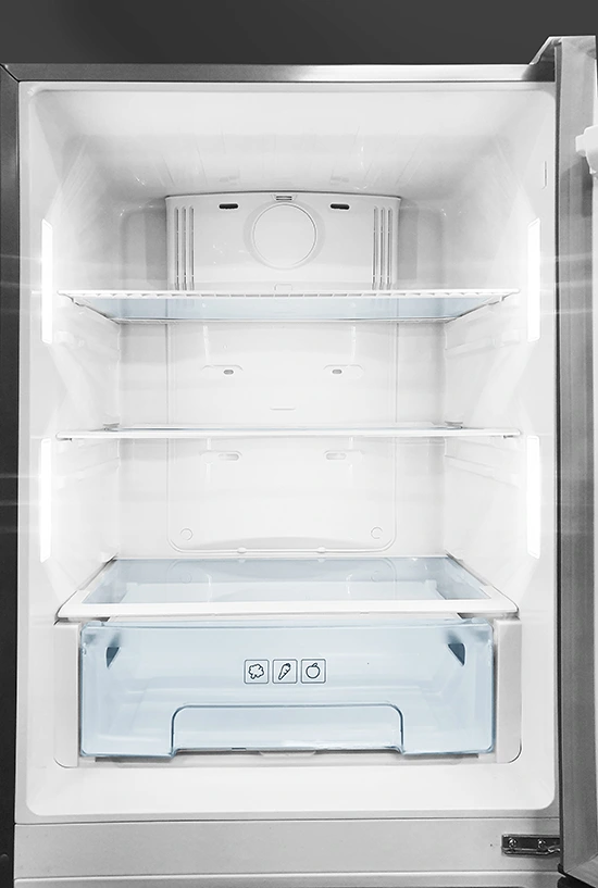 Vertical view of a clean, empty refrigerator interior with glass shelves and a crisper drawer.
