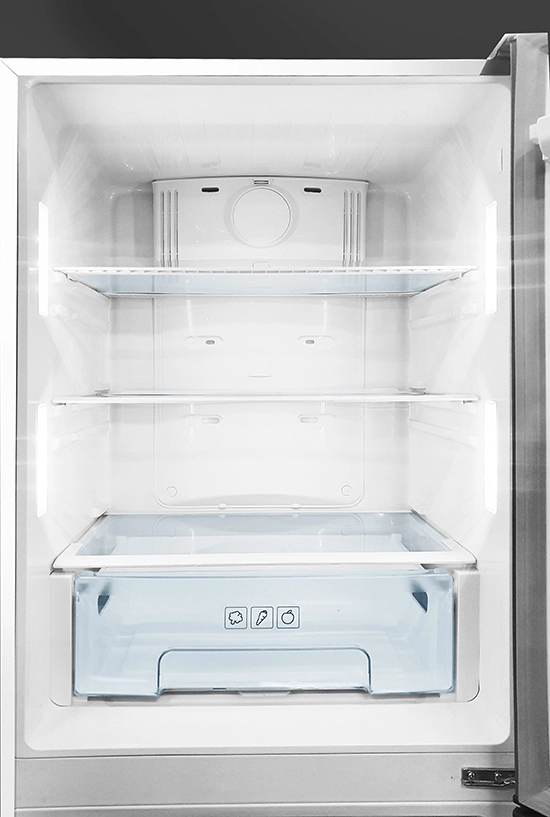 Open empty refrigerator interior showing glass shelves, LED lighting, and a bottom crisper drawer with food icons.