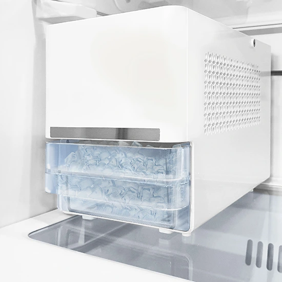 White portable ice maker with a clear bin full of ice cubes sitting on a refrigerator shelf.